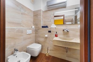 A modern bathroom with a bidet, sink, and mirror. - Azalea Apartment – Peaceful Retreat with Mountain Views (Induno Olona)