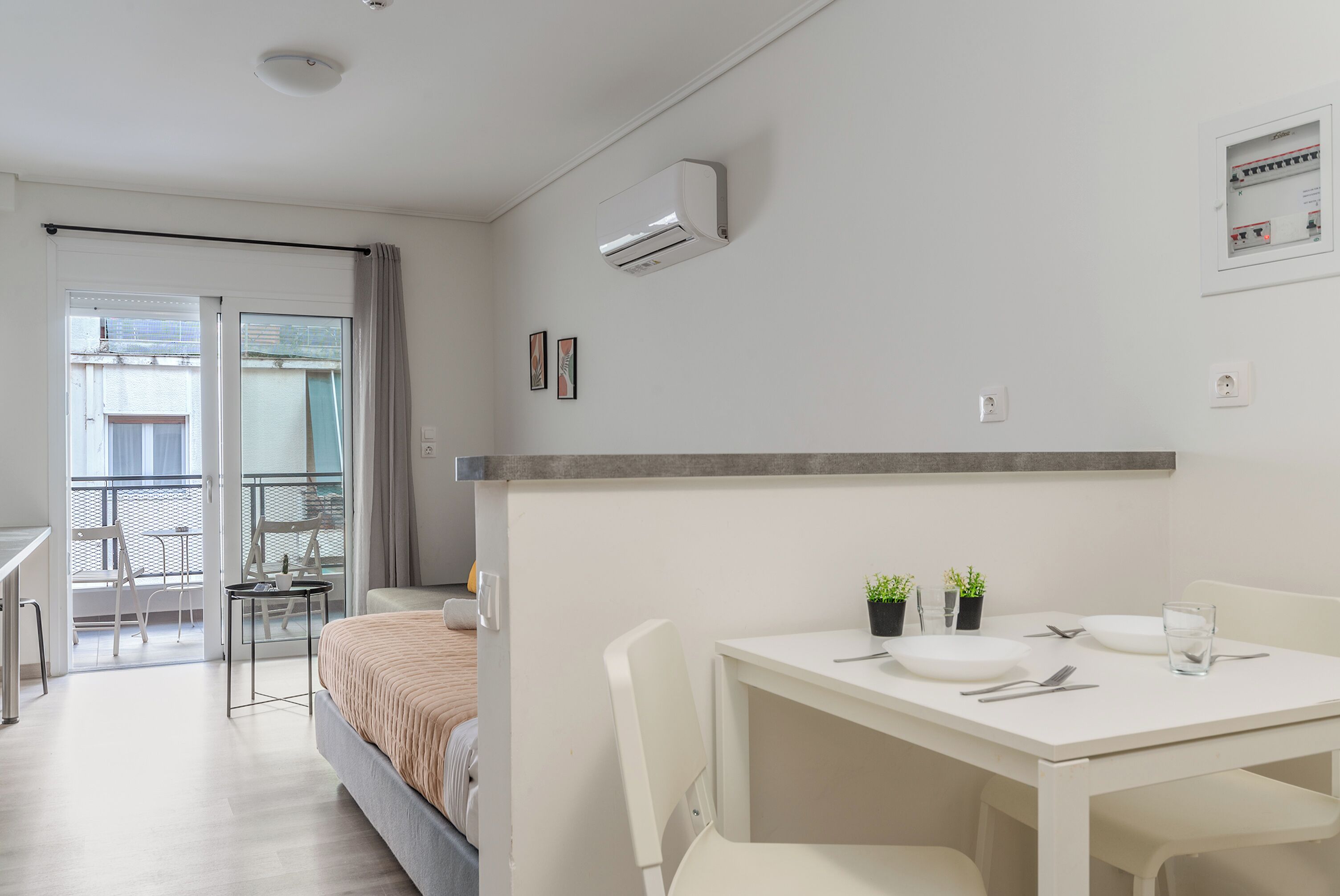 Moderni hotellihuone, jossa on parveke, ruokailutila ja sänky.