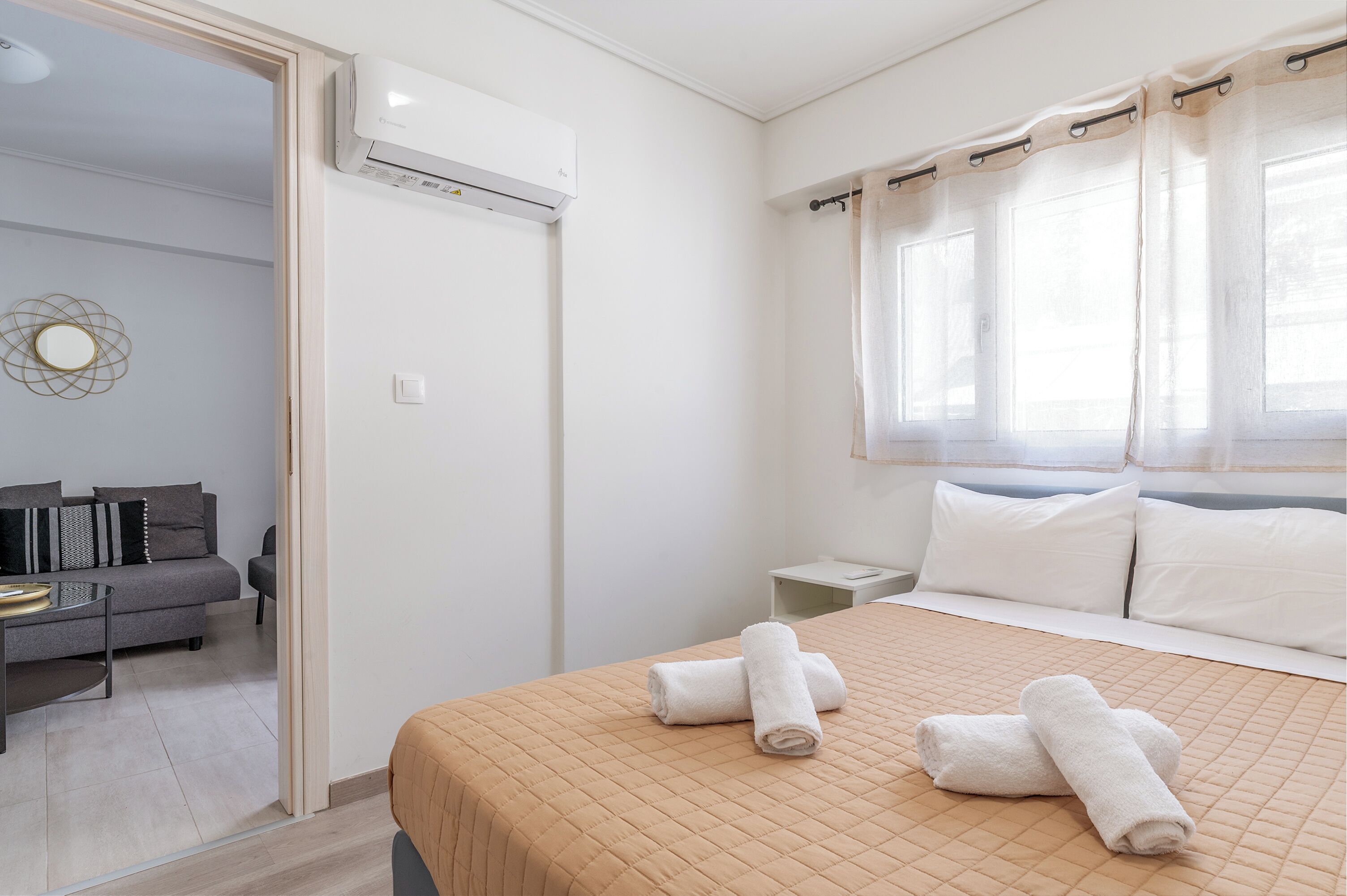 Une chambre d’hôtel équipée d’un lit, d’une table de chevet, d’un canapé et d’un appareil de climatisation.