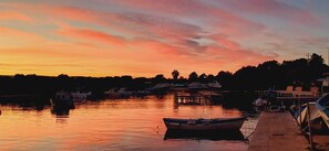 A marina at sunset with boats docked, a dock, and a calm water surface. - Villa Thalassa, for a perfect stay, 500 meters from the sea (Fontane Bianche)