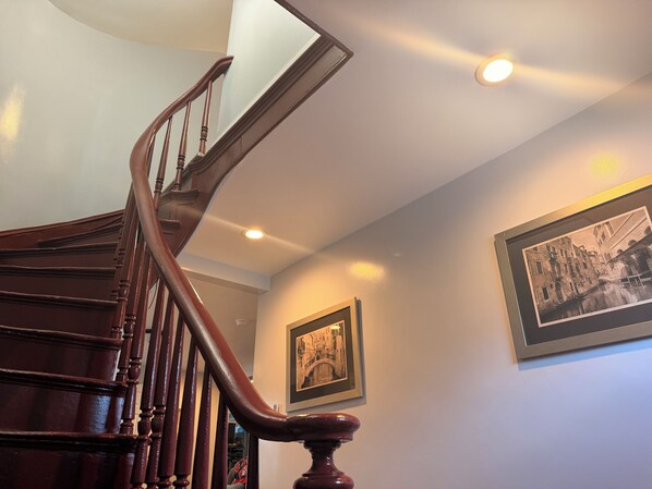 Una escalera de madera con barandilla que lleva a un piso superior.