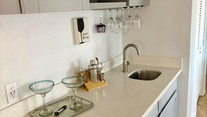 Eine Küche mit Arbeitsplatte, Spüle und Weinkühlschrank.