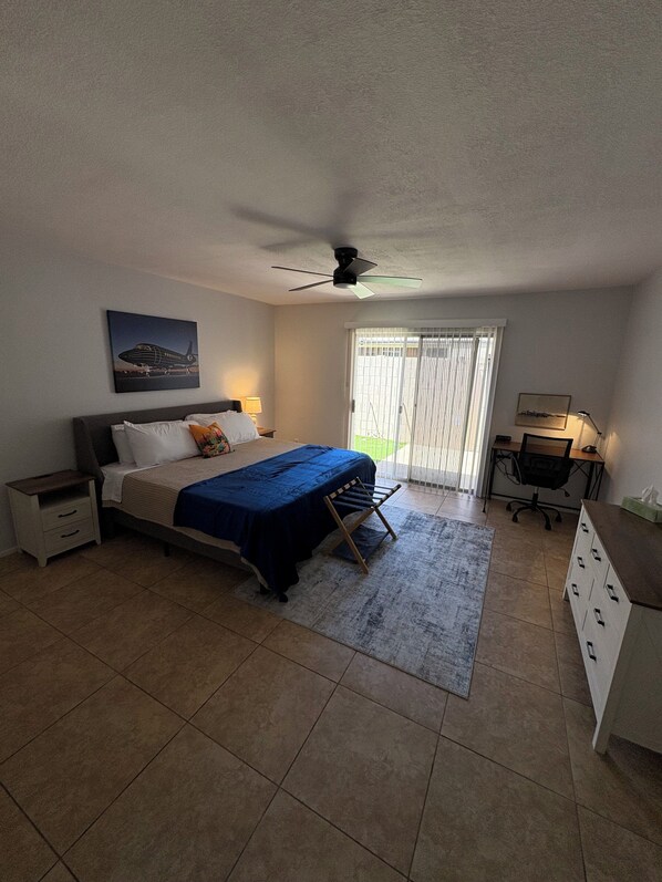 A bedroom with a bed, a desk, a chair, a ceiling fan, and a window with blinds. - Cozy 2-bedroom Golf course get away close to hospitals and attractions (Glendale)