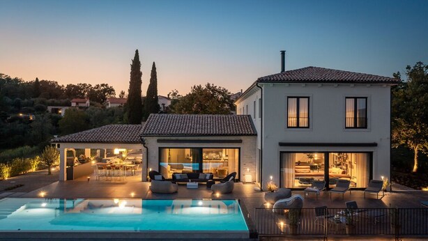 Ein modernes Haus mit Swimmingpool, Sitzgelegenheit im Freien und einer großen Terrasse.