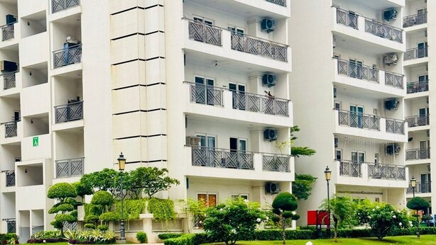 Un edificio de varios pisos con balcones, piscina y un jardín bien cuidado.