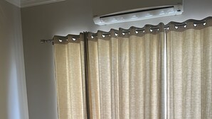 Un dormitorio con una cama, una alfombra y cortinas.