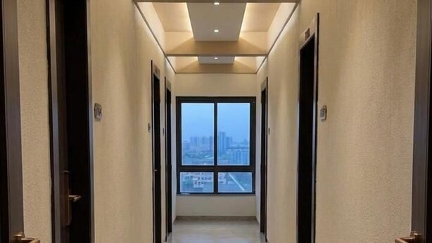 Pasillo de hotel con puertas, piso reflectante y vistas a través de las ventanas.