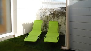 Two green lounge chairs with a white wall and a window in the background. - Gîte Mer et Marais at Soleil Levant (Bouin)