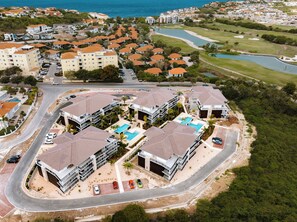 A residential area with multiple buildings, a swimming pool, and a golf course.