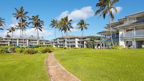 Ein Resort mit mehrstöckigen Gebäuden, Palmen und einem gepflegten Rasen.
