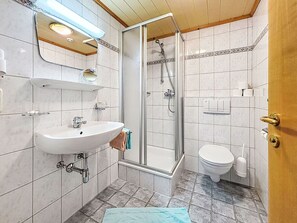 Een badkamer met wastafel, toilet en douche.