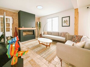 Ein Wohnzimmer mit Kamin, Sofa und Couchtisch.