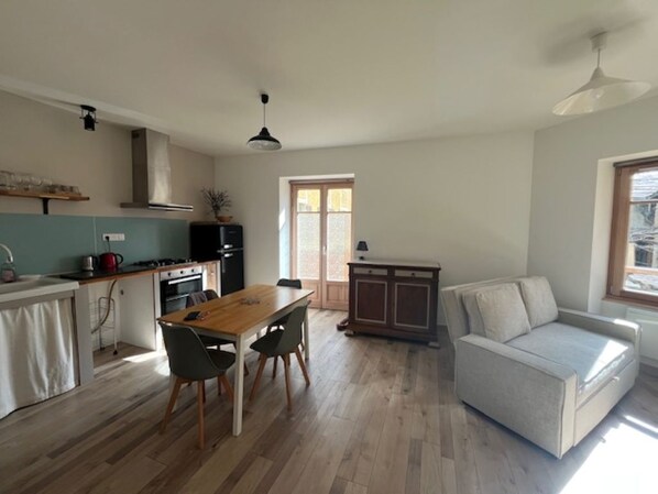 Una cocina moderna con una mesa de comedor y sillas, un sofá y un armario.