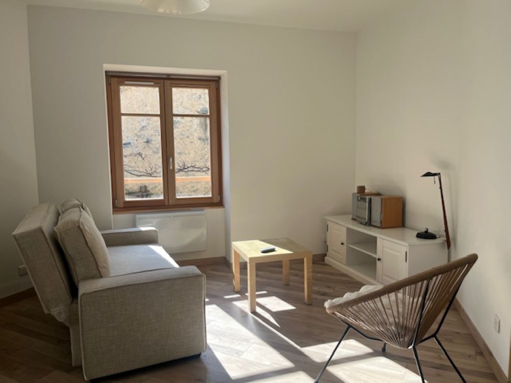 A room with a sofa, a small table, a chair, a cabinet, and a window with a view.. A stone's throw from the CENTRE: ALL-CONVENIENCE APARTMENT WITH CLOSE CONVENIENCES!