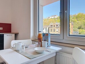 Ein Essbereich mit einem Tisch für zwei Personen, einer Saftflasche, einer Schüssel und einer Speisekarte.