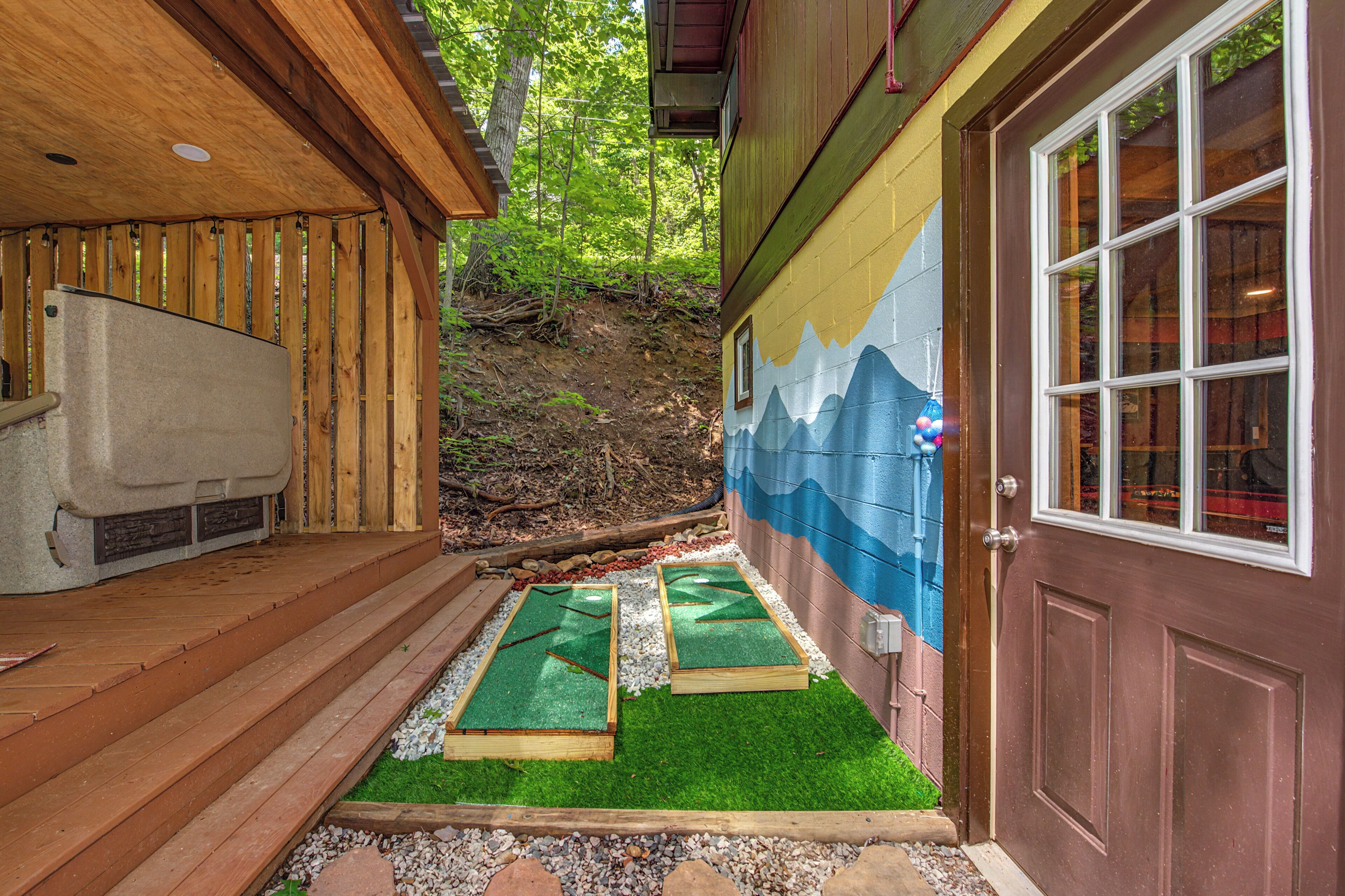 A wooden deck with a refrigerator, a door with a window, and a mural on the wall.