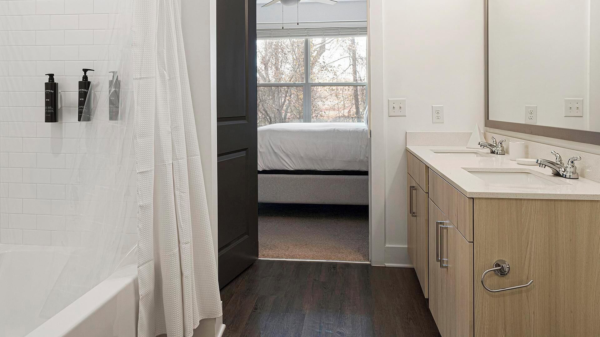 A modern bathroom with a bathtub, a shower area, and a vanity with a mirror.
