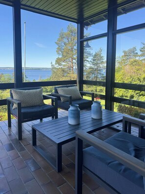 A covered outdoor seating area with a view of the water and trees. - Cottage in Jeløy nature reserve with fjord view (Moss)