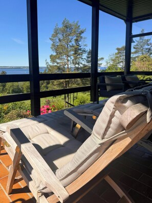 A covered outdoor seating area with a view of the sea and trees. - Cottage in Jeløy nature reserve with fjord view (Moss)