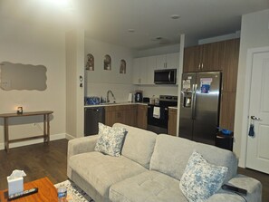 Ein Wohnzimmer mit einer Couch, einem Couchtisch und einer Fernbedienung.