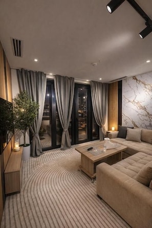 A modern living room with a sofa, a coffee table, and a potted plant.