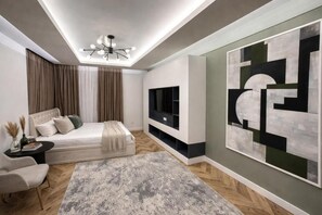 A modern bedroom with a bed, TV, and abstract art. - Nestone - Apartment Hotels (Tashkent)