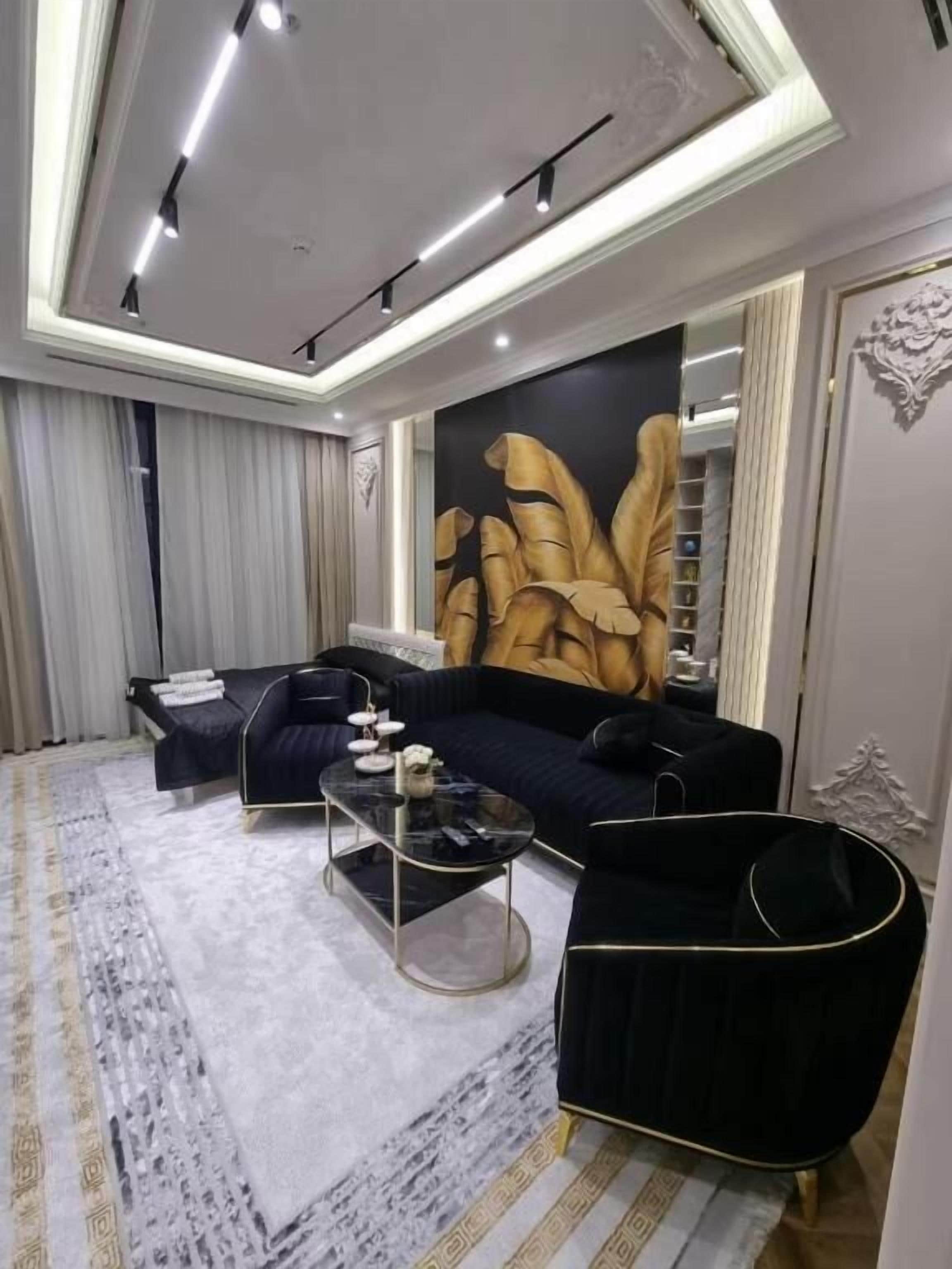 A modern living room with a sectional sofa, a coffee table, and a large abstract painting on the wall.