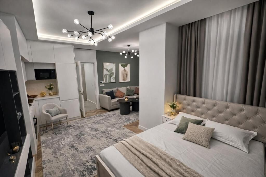 A modern bedroom with a large bed, a TV, and a ceiling light fixture.