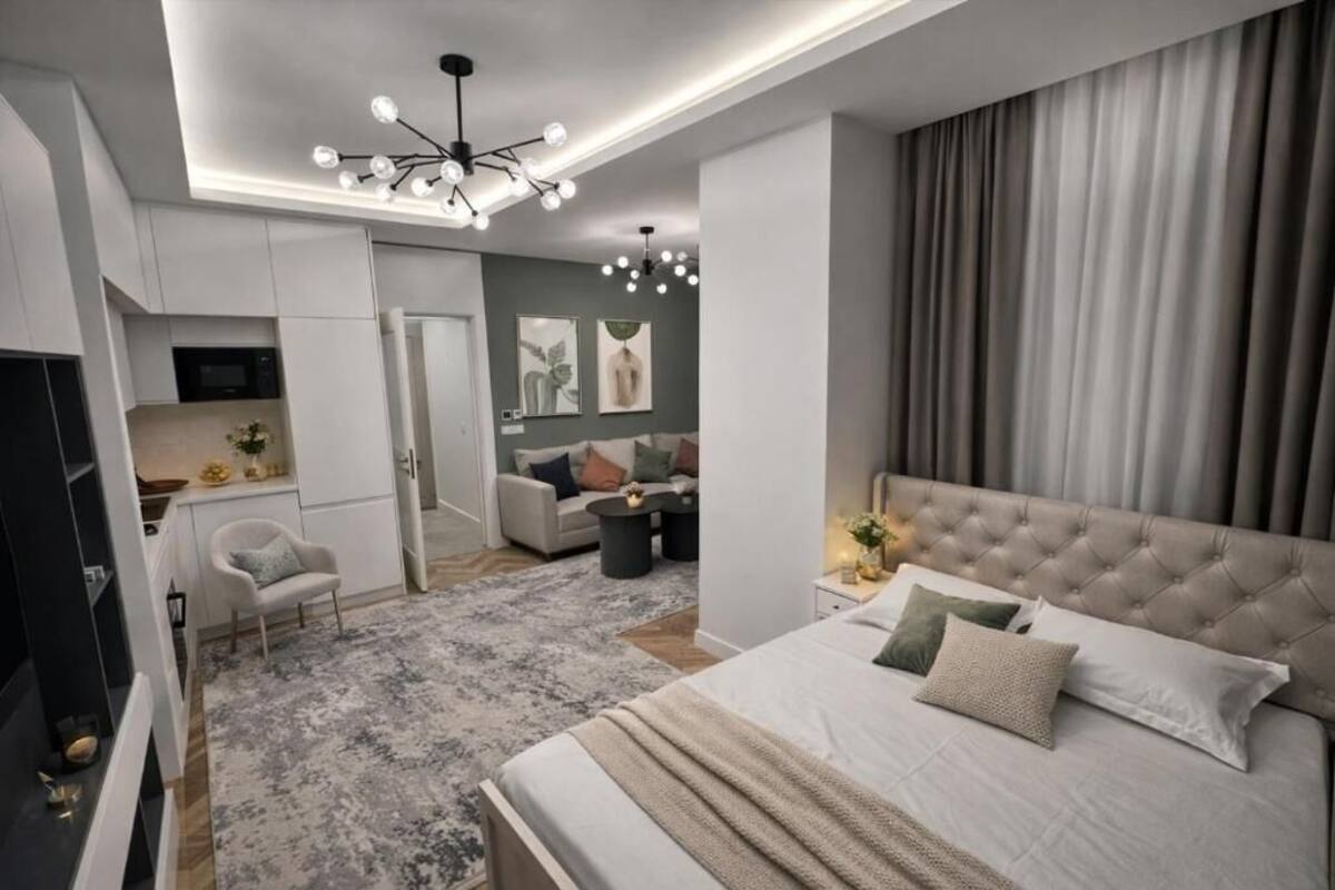 Un dormitorio moderno con una cama grande, un televisor y una lámpara en el techo.