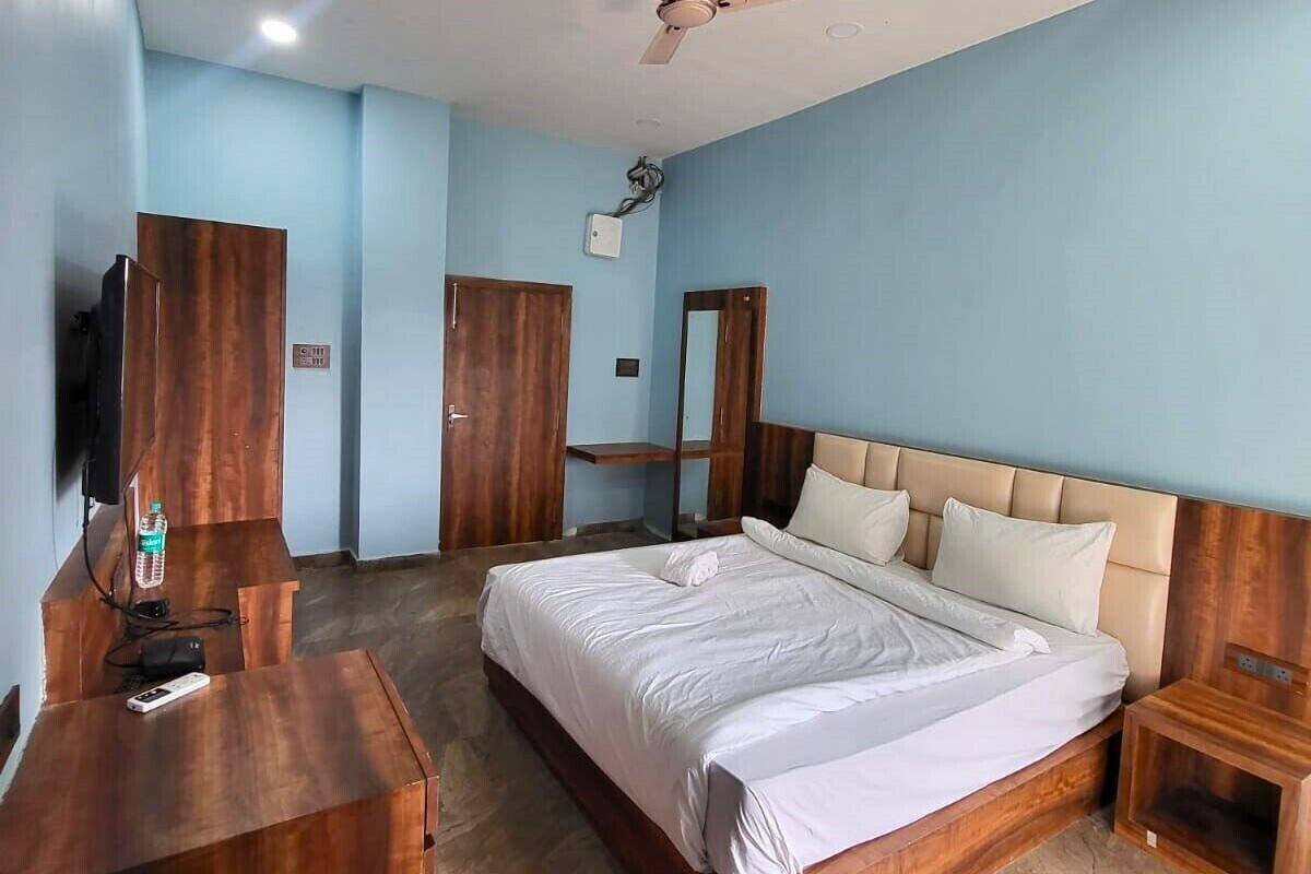Un dormitorio con cama, muebles de madera, ventilador de techo y televisor.