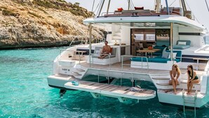 Uno yacht con un ponte coperto, zone relax e un tavolino.