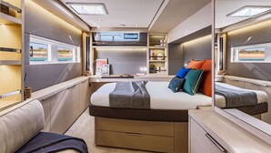 Un interno compatto e moderno con un letto, comodini, una mensola a muro e una finestra con vista.