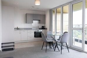 Eine moderne Küche mit Essbereich, großen Fenstern und Blick ins Freie.