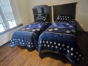 A bedroom with two beds, each with a headboard and matching pillows.