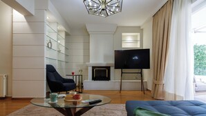 Ein modernes Wohnzimmer mit Kamin, Fernseher und einer gemütlichen Sitzecke.