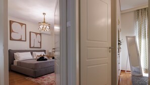 Ein Schlafzimmer mit einem Bett, einem Nachttisch, einer Lampe und einem Kronleuchter.