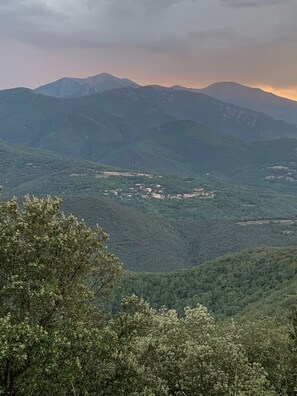 A mountainous landscape with a valley and a small settlement.