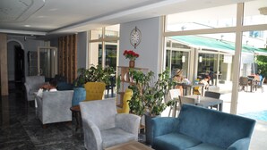 A hotel lobby with seating areas, a clock on the wall, and large windows. - Citrus Urban (Konyaaltı)