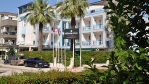 A hotel with a modern design, featuring balconies, palm trees, and a sign indicating it's a hotel. - Citrus Urban (Konyaaltı)