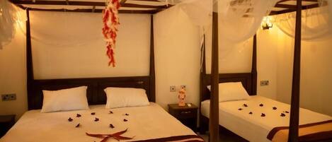A double bed with a canopy, a bedside table, and a nightstand.