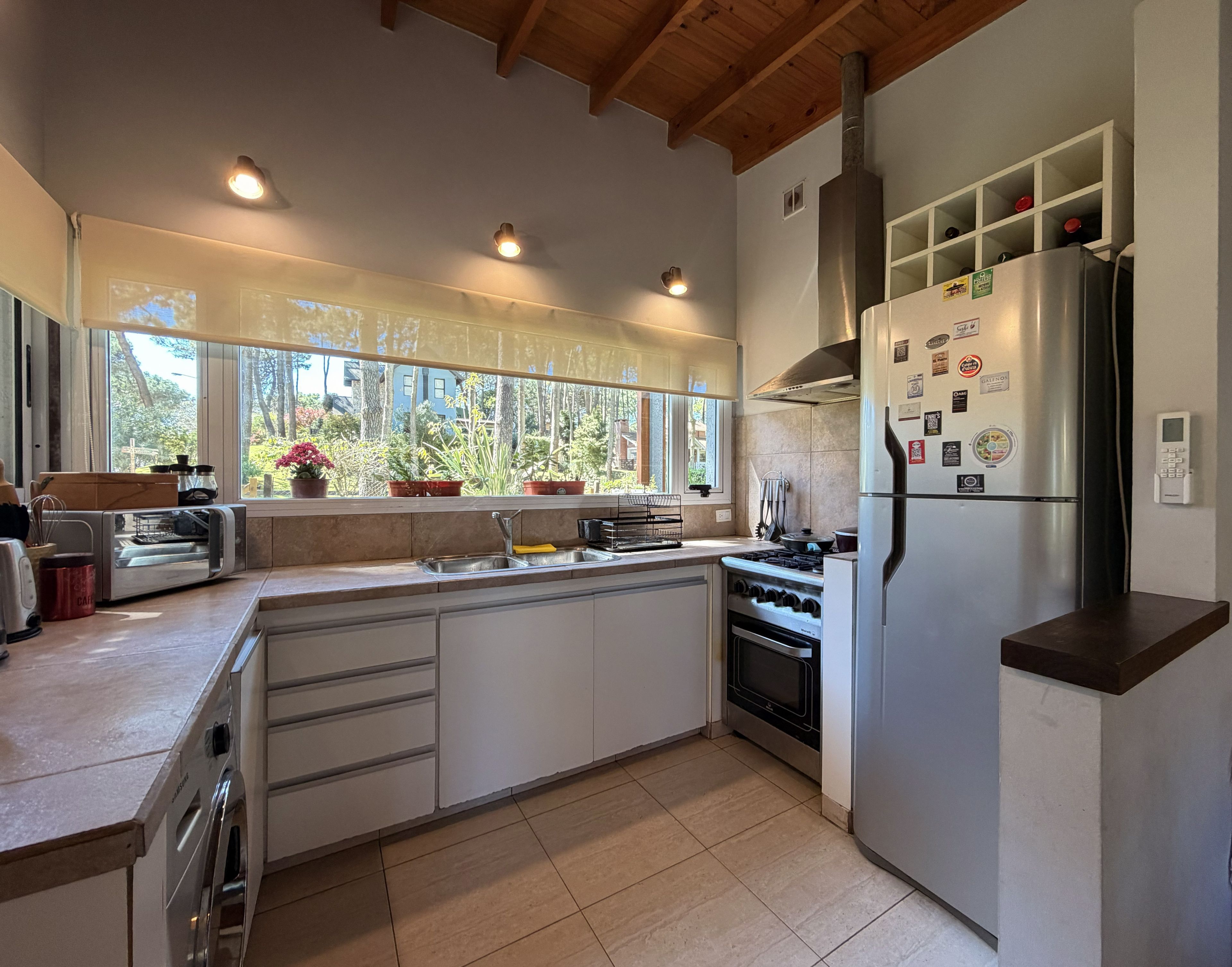 Una cocina moderna con una isla grande, electrodomésticos de acero inoxidable y vistas al exterior.