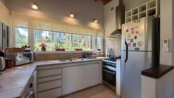 Una cocina moderna con una isla grande, electrodomésticos de acero inoxidable y vistas al exterior.