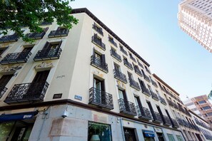 A multi-story building with balconies, a sign indicating a restaurant, and a visible window with a view. - Central 2BD Apt Facing Torre Madrid Duque de Osuna (Madrid)
