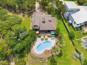 A large house with a swimming pool, deck, and outdoor seating area. - The Lakeside Soundtrack | Pool, Hot Tub, Games (Spicewood)
