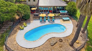 A house with a swimming pool, outdoor furniture, and a patio area. - The Lakeside Soundtrack | Pool, Hot Tub, Games (Spicewood)
