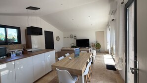A modern kitchen with a dining area, a TV, and a large window. - House with private spa and large garden - Provence Luberon (La Bastidonne)