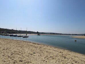 Ein Sandstrand mit Booten, die am Ufer liegen.
