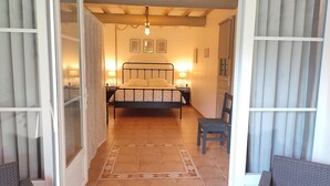 A bedroom with a bed, bedside lamps, a chair, and a patterned rug. - The Bicentennial Linden Cottage (Pernes-les-Fontaines)