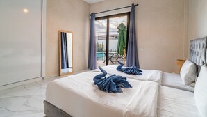 Habitación de hotel con cama, espejo, ventana con cortinas y vista a un espacio exterior.