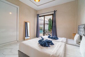 Ein Hotelzimmer mit Bett, Spiegel, einem Fenster mit Vorhängen und Blick auf einen Außenbereich.